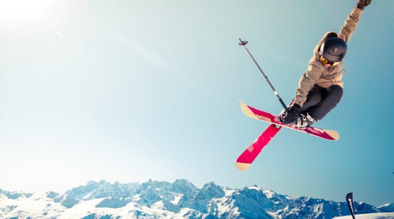 person in brown jacket doing snow ski blade trick